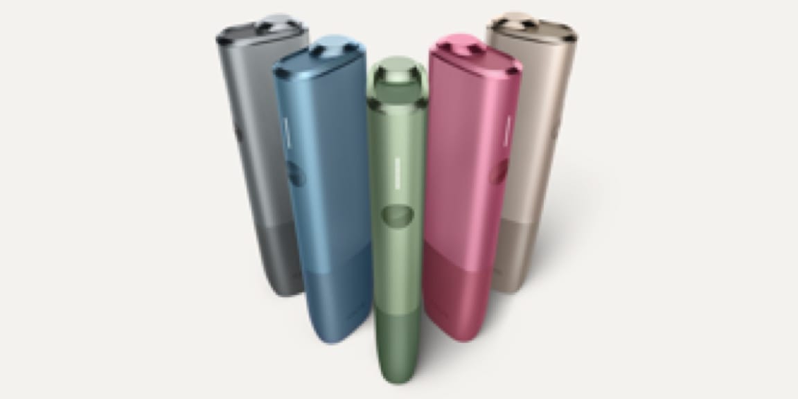 Пять устройств IQOS ILUMA ONE разных цветов стоят вместе.